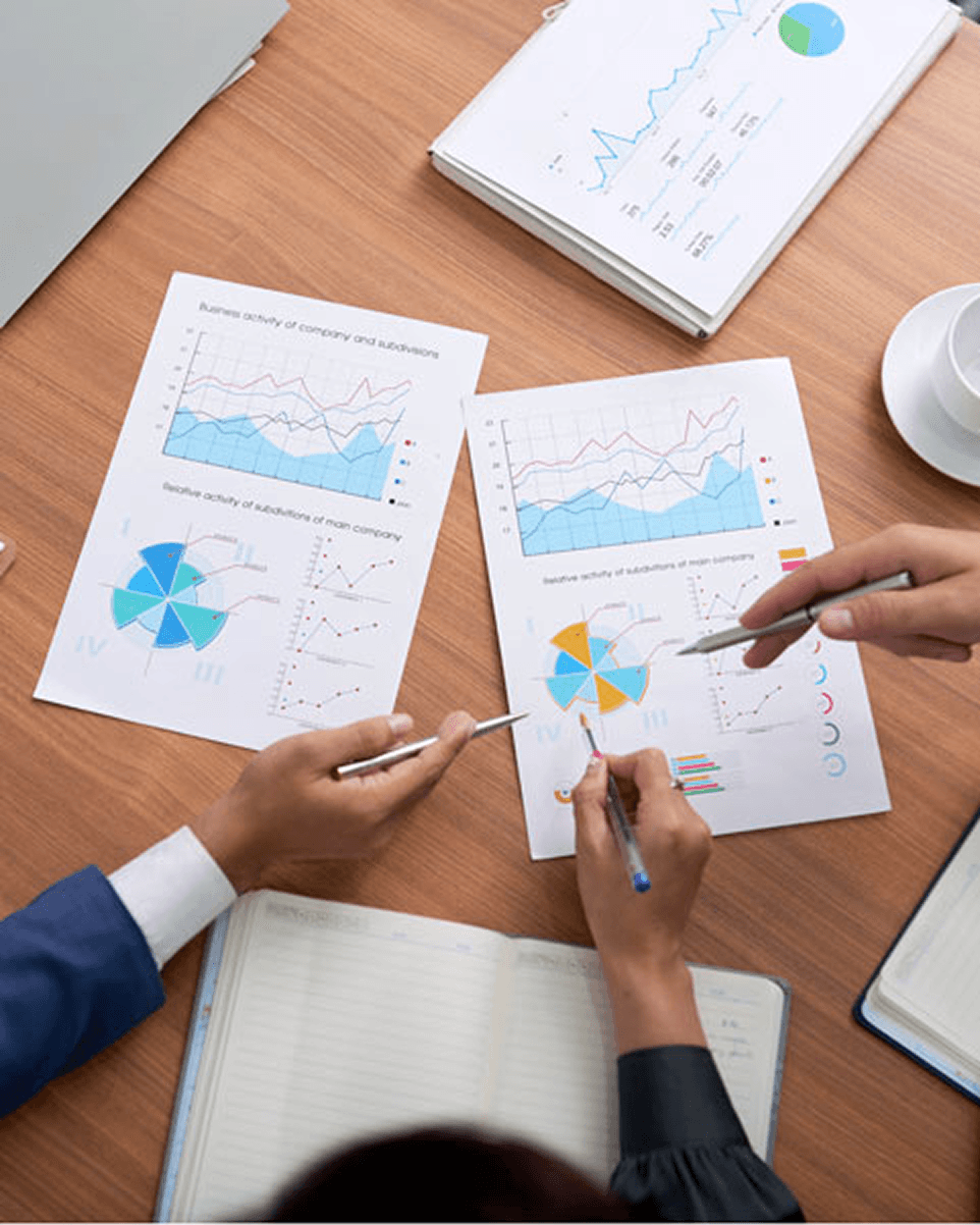 Professionnels étudiant des indicateurs économiques et financiers sur des rapports graphiques