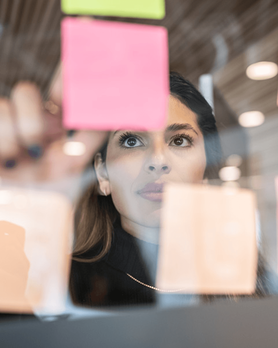 Brainstorming sur une vitre avec post-its lié au développement de produits de consommation