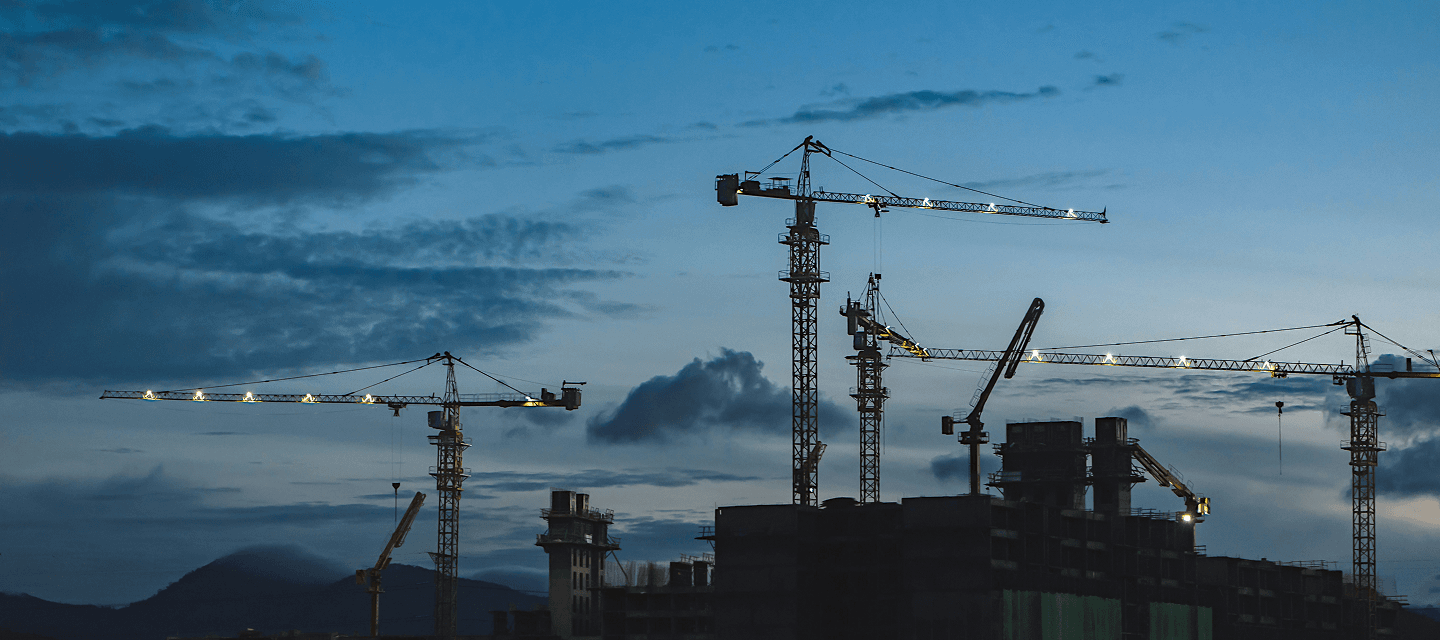 Grues et bâtiments en chantier au crépuscule - illustration du secteur de la construction