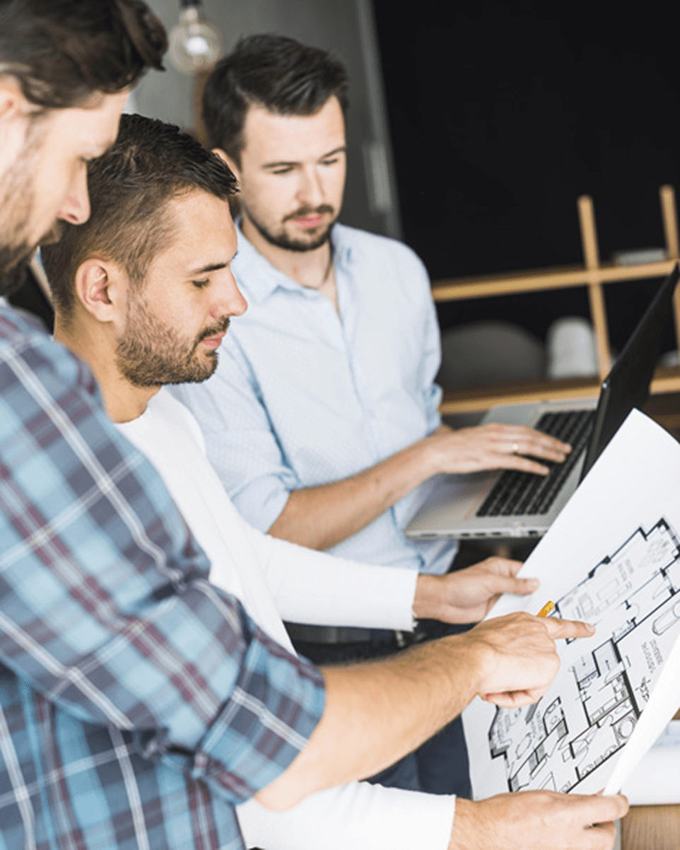 Professionnels analysant un plan architectural dans un projet de construction