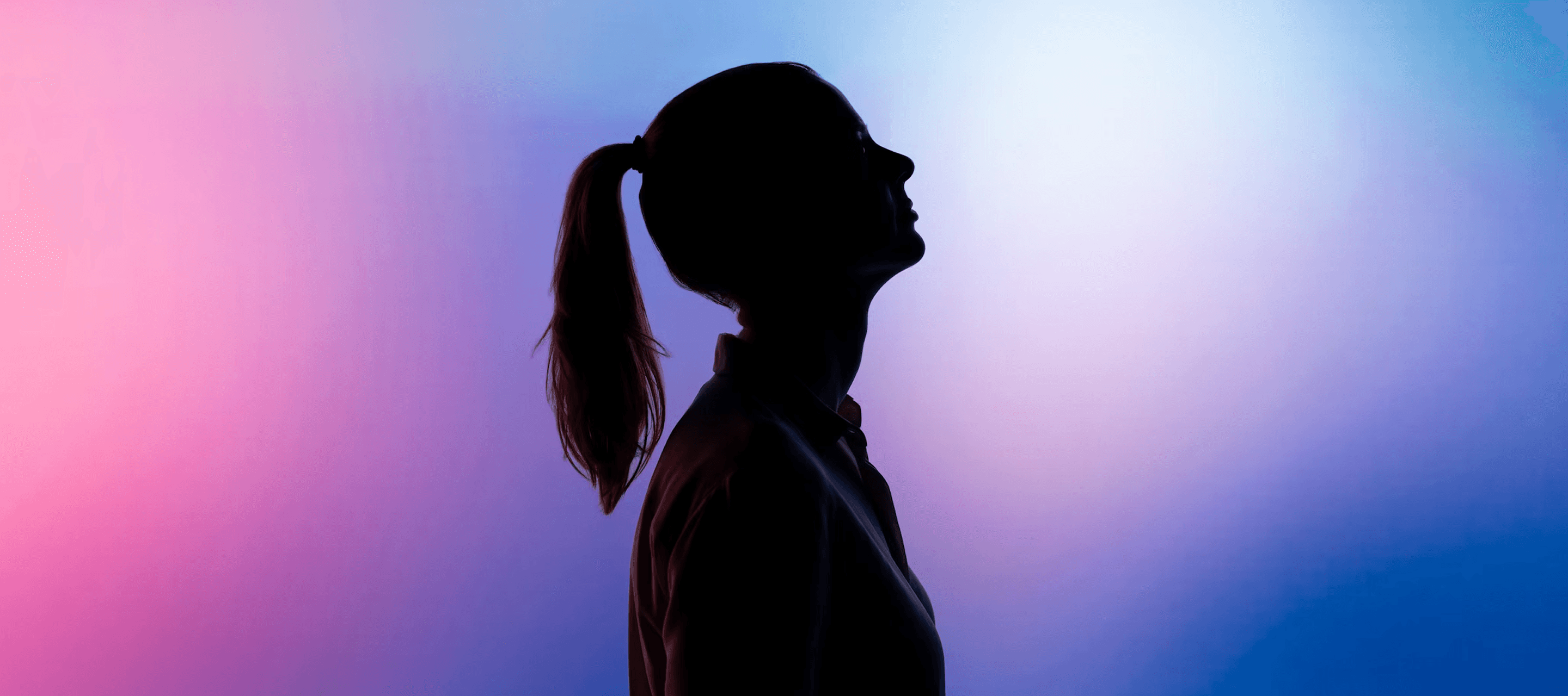 Silhouette d’une personne devant un fond lumineux coloré - illustration du secteur technologie et digital